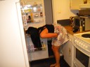 Sandra letar långt in i kylskåpet efter något.